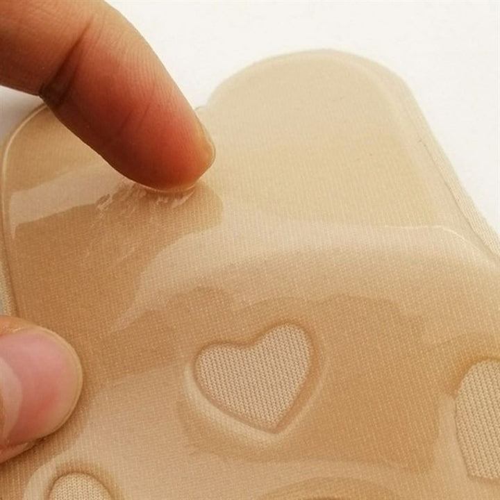 A hand peels a Shapelux Lifting Pad for Invisible Breast Lift, showing the strong adhesive beige tape—an ideal strapless bra alternative for discreet support.