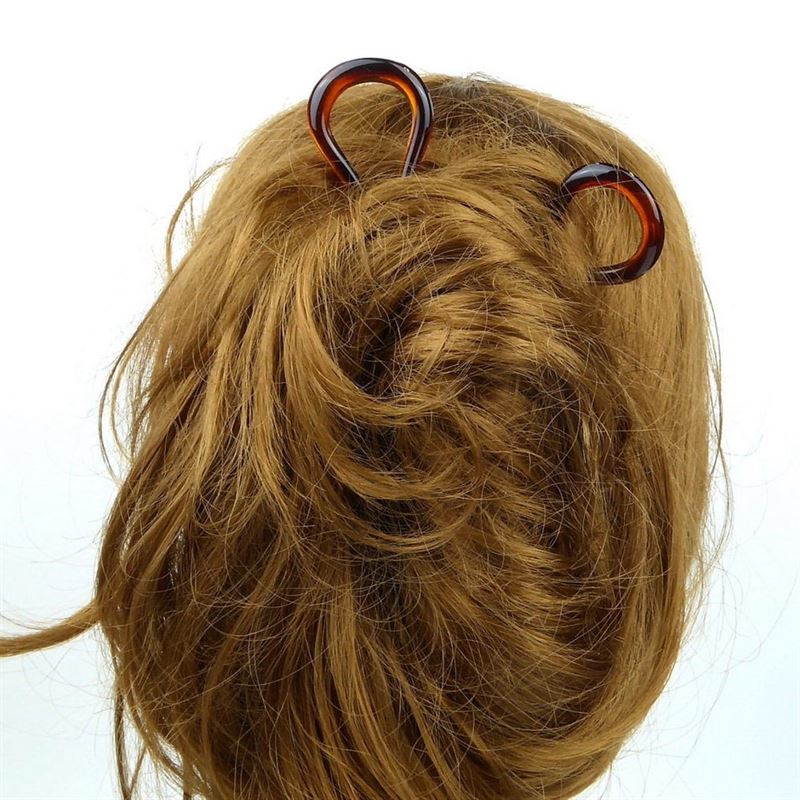 A close-up shows the back of a person’s head with light brown hair in a messy bun, secured by a SOHO Twist Chignon Hairpin from the pack of 3. The background is plain white.