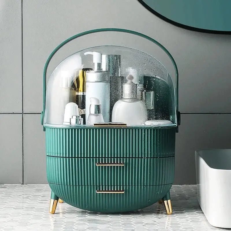 The UNIQ Retro Makeup Box Organiser in Dark Mint/Dark Green by UNIQ features a ribbed design and clear dome lid, perfect for storing skincare and makeup bottles. It sits on a hexagonal tile countertop below a mirror against gray tiled walls.