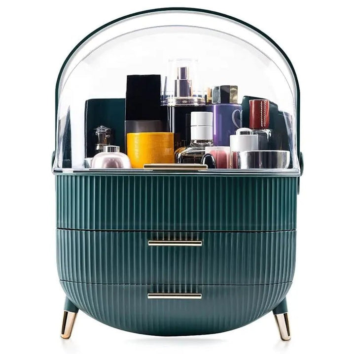 The UNIQ Retro Makeup Box Organiser in Dark Mint/Dark Green by UNIQ features a dome lid, gold legs and handles, two drawers, and a clear top compartment—blending retro charm with modern storage for skincare and makeup essentials.