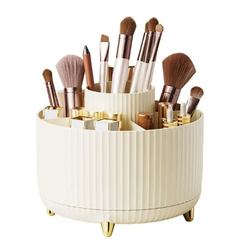 The UNIQ Rotating Makeup Organiser in Cream White by UNIQ features a round, tiered design with gold accents, holding brushes and cosmetics. This elegant organiser keeps your beauty essentials within easy reach and enhances your storage space.