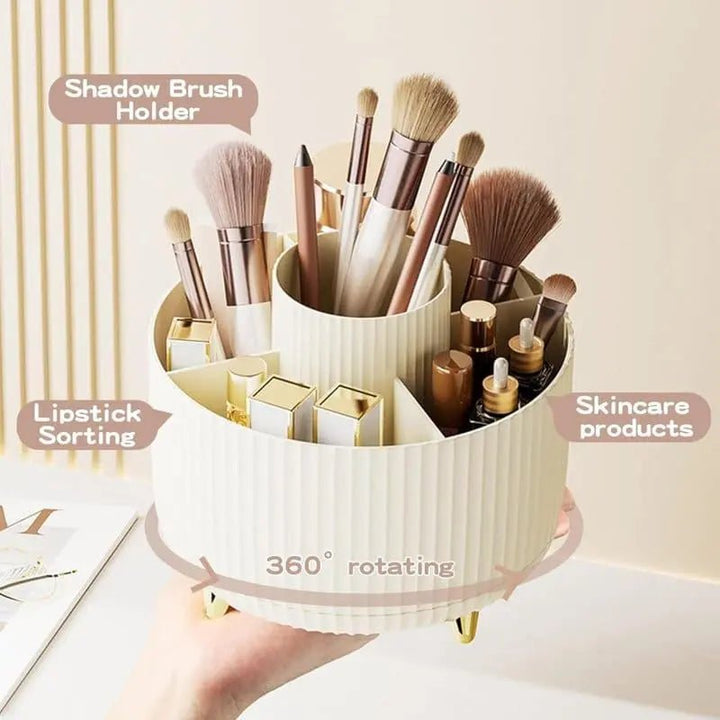 A hand holds the UNIQ Rotating Makeup Organiser in Cream White, featuring a 360-degree spin and labeled sections, neatly storing brushes, lipsticks, pencils, and skincare—perfect for easy cosmetics organisation by UNIQ.